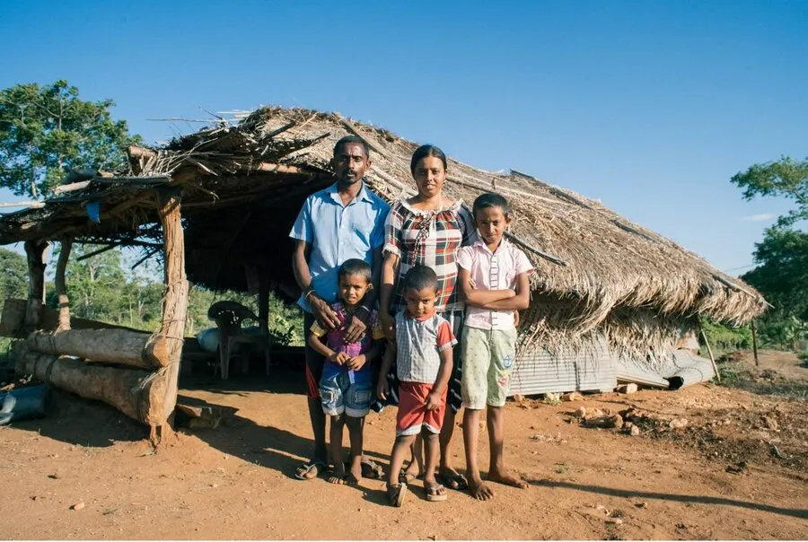 A farming family in front of their home near Kandy